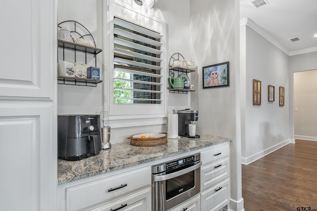 7306 Tule Creek Ln, Tyler, TX 75703 - kitchen with crown molding, light stone counters, white cabinets, and dark wood-style floors