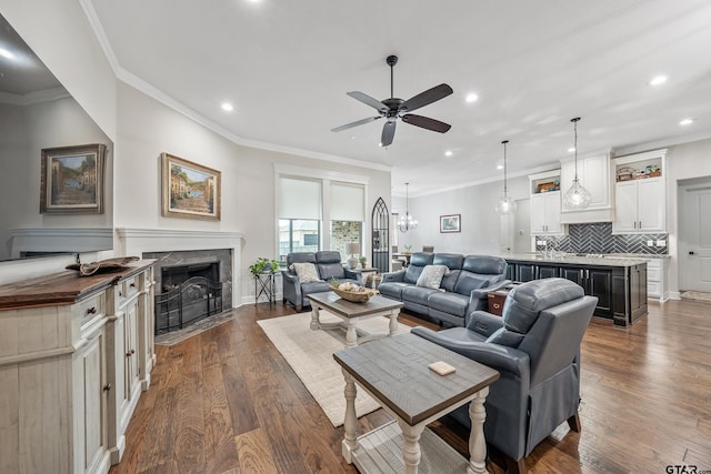 7306 Tule Creek Ln, Tyler, TX 75703 - living room with ceiling fan, recessed lighting, dark wood-style flooring, a fireplace with flush hearth, and ornamental molding