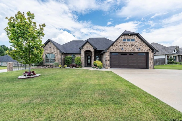 7306 Tule Creek Ln, Tyler, TX 75703 - french provincial home featuring brick siding, a garage, driveway, and roof with shingles