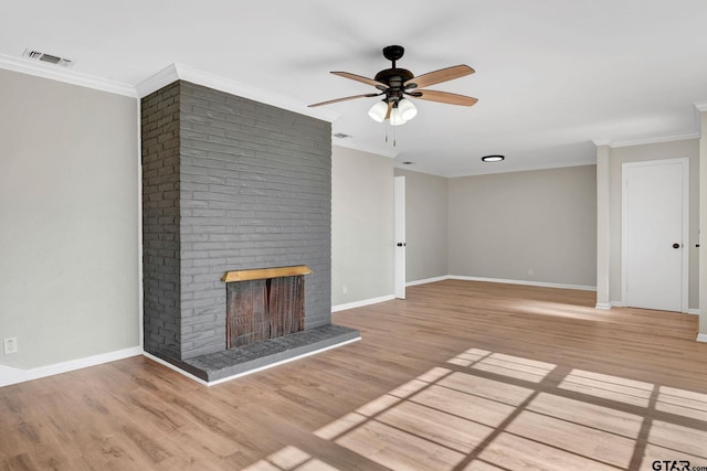 unfurnished living room with ceiling fan, light wood-type flooring, a brick fireplace, and ornamental molding