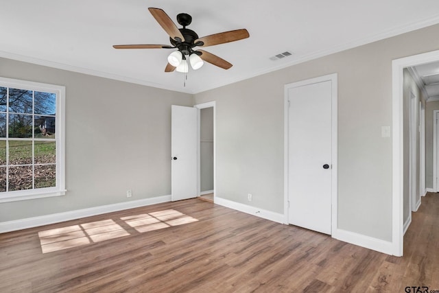 unfurnished bedroom featuring ceiling fan, ornamental molding, and hardwood / wood-style flooring