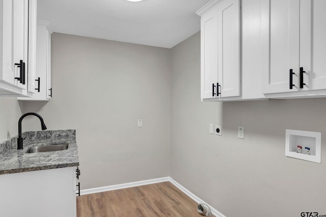 laundry area featuring cabinets, light hardwood / wood-style floors, sink, hookup for a washing machine, and hookup for an electric dryer