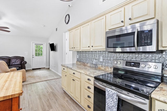 321 Inwood, Bullard, TX 75757 - kitchen with lofted ceiling, decorative backsplash, stainless steel appliances, light wood-type flooring, and cream cabinets