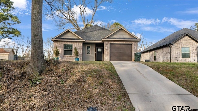 view of front of home with a garage, driveway, and brick siding