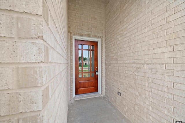 property entrance featuring brick siding