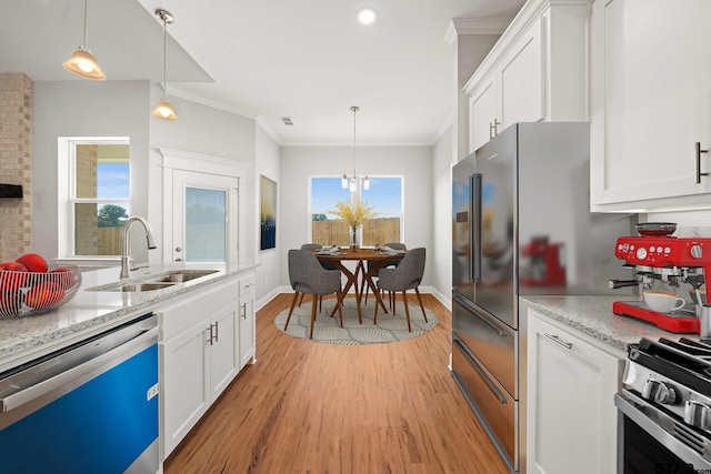 kitchen with crown molding, appliances with stainless steel finishes, a sink, white cabinets, and light wood-style floors