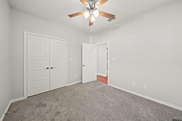 unfurnished bedroom with ceiling fan, visible vents, carpet floors, baseboards, and a closet