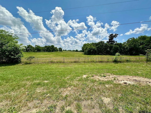 view of yard featuring fence and a rural view