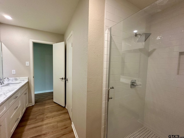 full bathroom featuring vanity, a shower stall, and wood finished floors