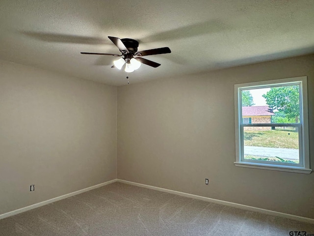 unfurnished room with a textured ceiling, ceiling fan, baseboards, and light carpet