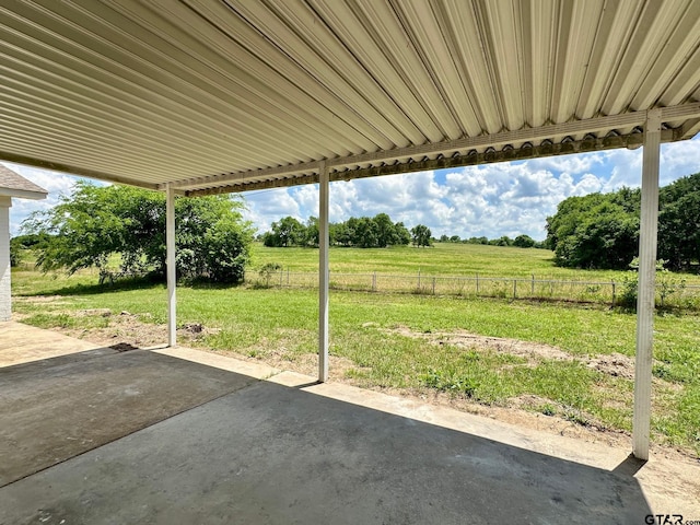 view of patio with fence and a rural view