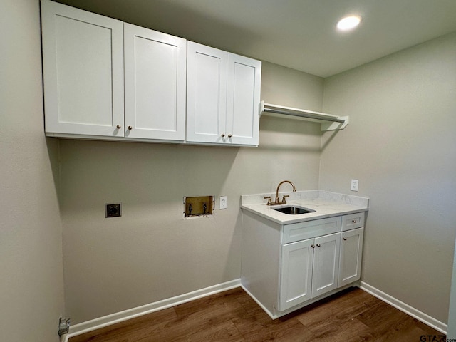 washroom with hookup for an electric dryer, cabinet space, a sink, washer hookup, and dark wood-type flooring