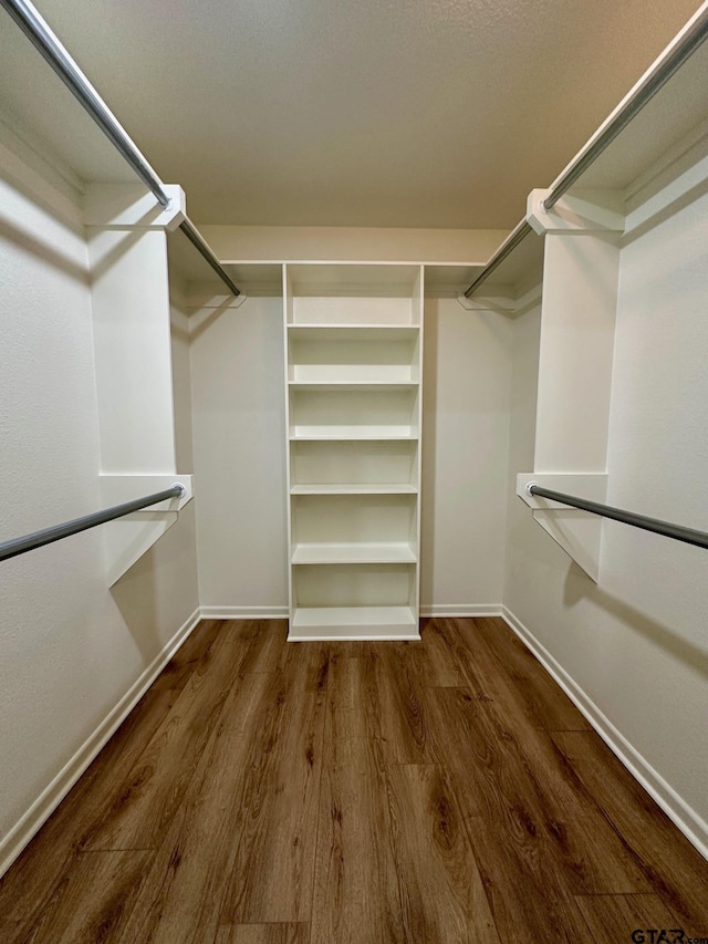 walk in closet with wood finished floors