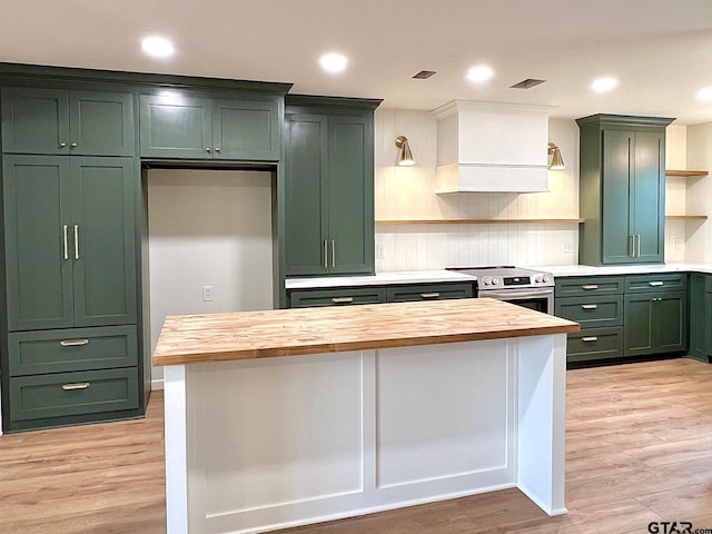 kitchen with wood counters, open shelves, light wood-style floors, green cabinets, and electric stove
