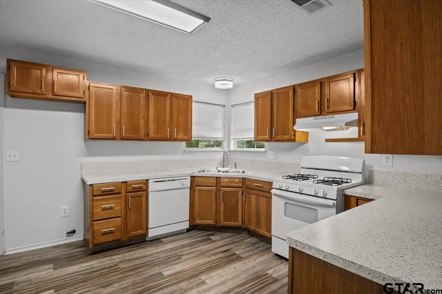 kitchen featuring a textured ceiling, sink, white appliances, and dark hardwood / wood-style floors