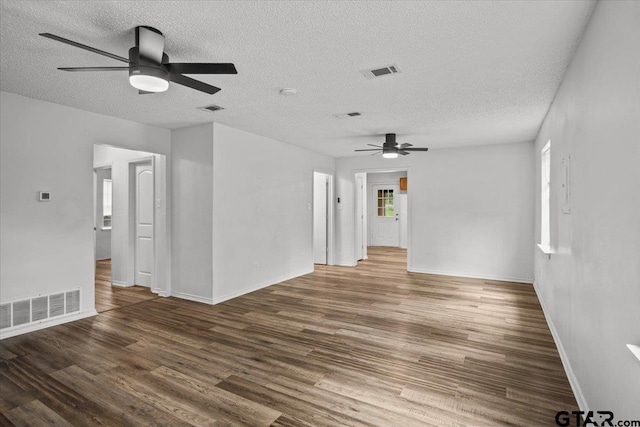 spare room with dark wood-type flooring, ceiling fan, and a textured ceiling