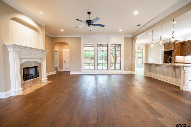 936 Cambridge Bnd, Tyler, TX 75703 - unfurnished living room featuring a ceiling fan, recessed lighting, ornamental molding, dark wood-style flooring, and a high end fireplace