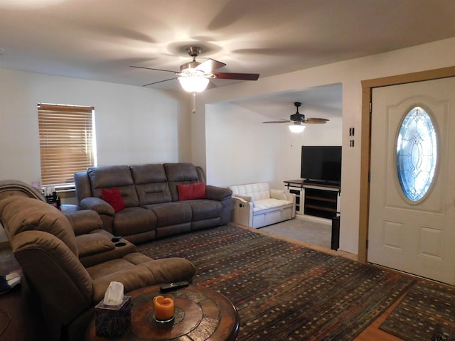 carpeted living area with a ceiling fan