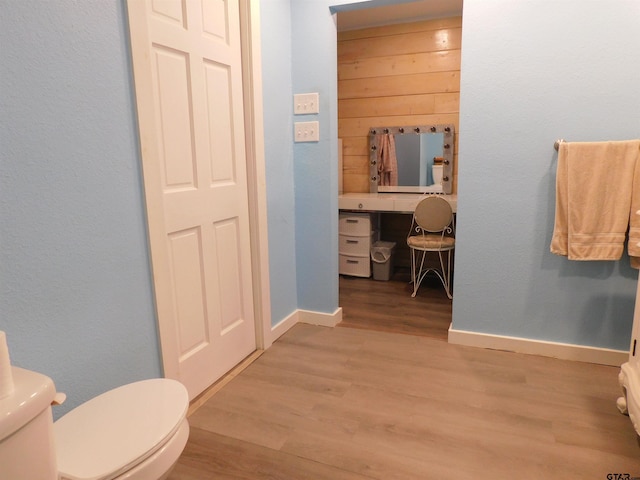 bathroom featuring toilet, wood finished floors, and baseboards