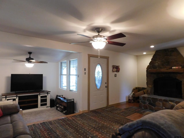 carpeted living room with vaulted ceiling, a fireplace, and ceiling fan