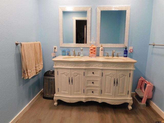 full bath featuring a sink, baseboards, and wood finished floors