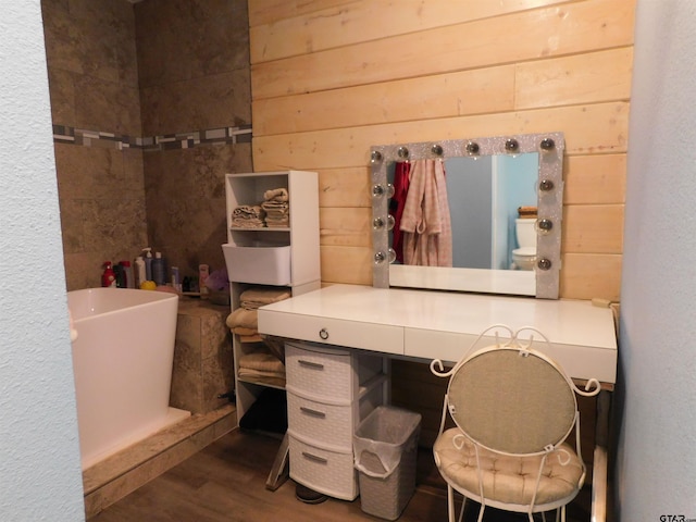 bathroom featuring wood finished floors and wood walls