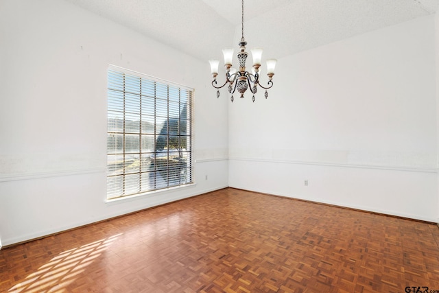 unfurnished room with parquet floors, a notable chandelier, a textured ceiling, and a wealth of natural light