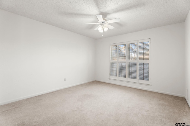 carpeted spare room with a textured ceiling and ceiling fan