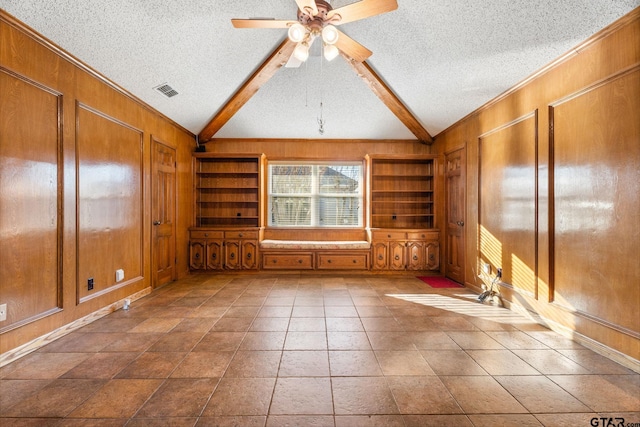 unfurnished room with lofted ceiling with beams, ceiling fan, and wood walls