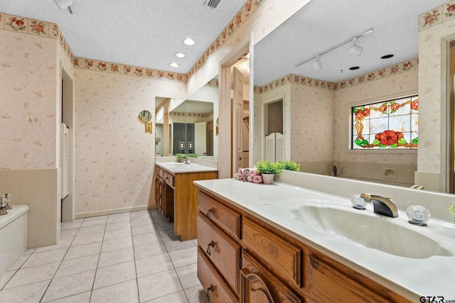 bathroom with tile patterned floors, a textured ceiling, and vanity