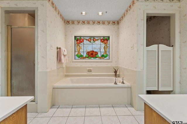 bathroom featuring tile patterned floors, vanity, separate shower and tub, and a textured ceiling