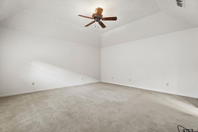 carpeted empty room with ceiling fan, vaulted ceiling, and a textured ceiling