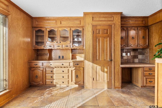 kitchen featuring a textured ceiling and wood walls