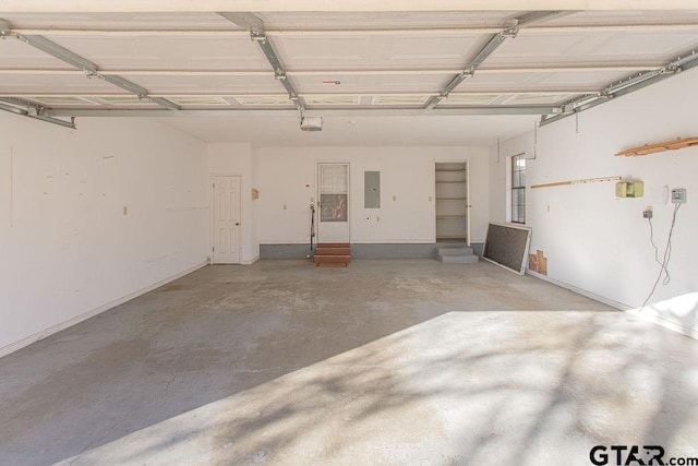 garage with a garage door opener and electric panel