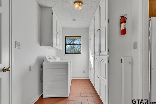 laundry area featuring cabinets, washer and clothes dryer, and light tile patterned floors