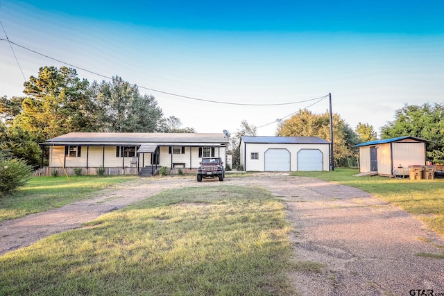 single story home with covered porch, a garage, a shed, and a front yard