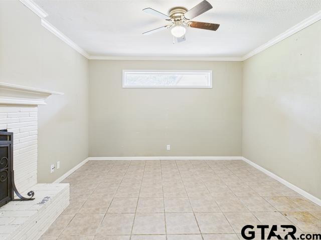 3323 S Keaton Ave, Tyler, TX 75701 - unfurnished living room with crown molding, a ceiling fan, baseboards, and light tile patterned flooring