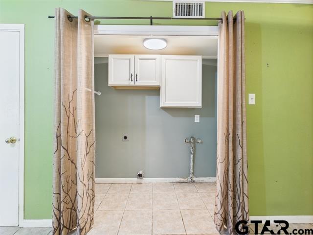 3323 S Keaton Ave, Tyler, TX 75701 - clothes washing area featuring electric dryer hookup, cabinet space, baseboards, and visible vents