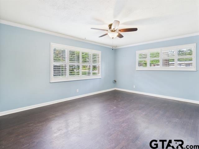 3323 S Keaton Ave, Tyler, TX 75701 - unfurnished room with baseboards, ornamental molding, a ceiling fan, and dark wood-style floors