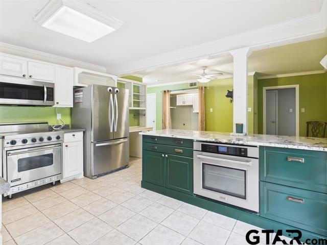 3323 S Keaton Ave, Tyler, TX 75701 - kitchen featuring appliances with stainless steel finishes, white cabinets, ornamental molding, green cabinetry, and light tile patterned flooring