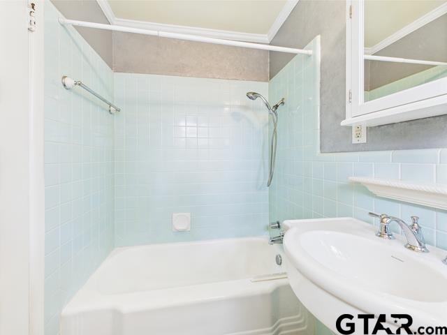 3323 S Keaton Ave, Tyler, TX 75701 - full bath featuring a sink, tile walls, crown molding, and shower / bath combination
