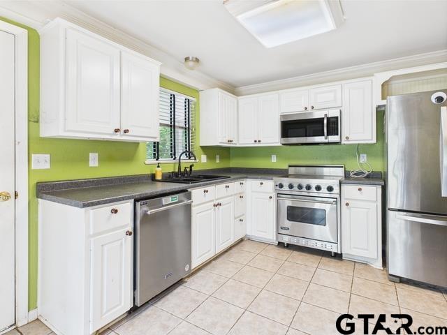 3323 S Keaton Ave, Tyler, TX 75701 - kitchen with a sink, appliances with stainless steel finishes, white cabinets, and dark countertops