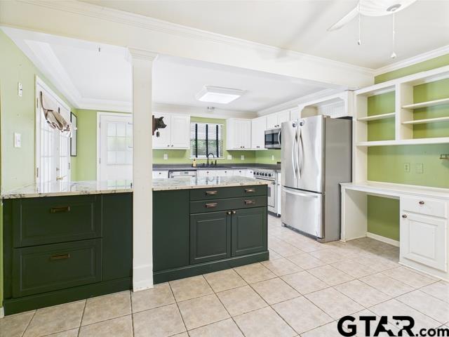 3323 S Keaton Ave, Tyler, TX 75701 - kitchen with a ceiling fan, light tile patterned floors, ornamental molding, stainless steel appliances, and white cabinetry