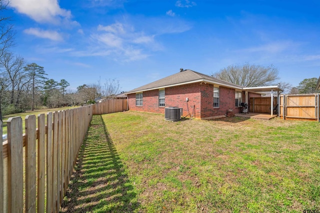 view of yard featuring a patio area, central air condition unit, a fenced backyard, and a gate