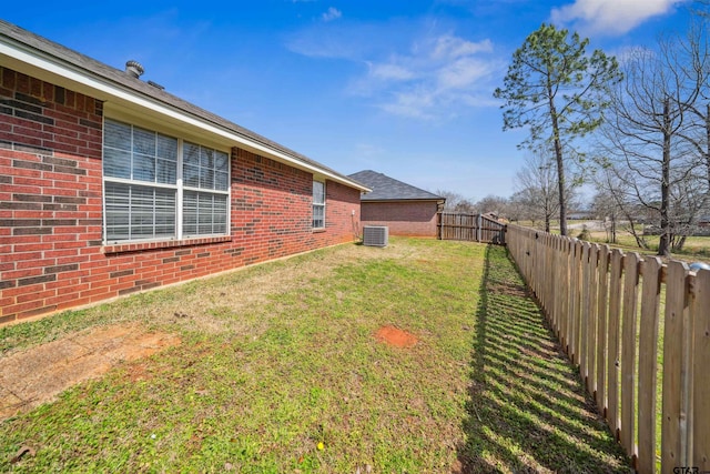 view of yard with central air condition unit and a fenced backyard