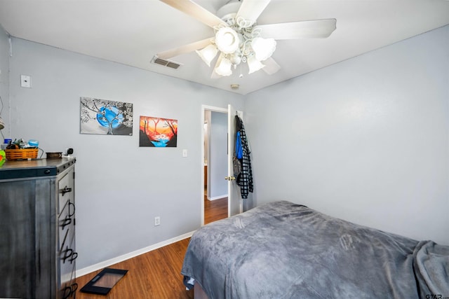 bedroom featuring dark wood finished floors, visible vents, ceiling fan, and baseboards