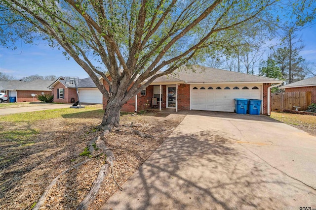 ranch-style house featuring a garage, brick siding, driveway, and fence