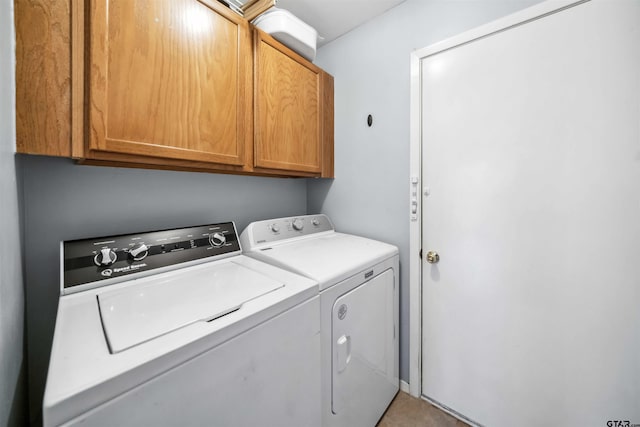 laundry area featuring washing machine and dryer and cabinet space