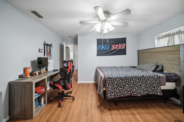 bedroom featuring visible vents, baseboards, ceiling fan, and wood finished floors