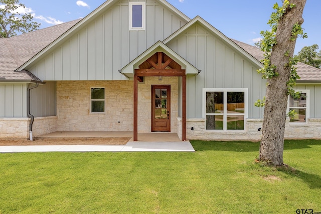 14524 Woodland Creek Dr, Tyler, TX 75706 - view of front of home with a shingled roof, board and batten siding, a front yard, and stone siding